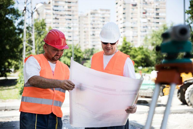 Dwóch mężczyzn czytających mapę geodezyjną